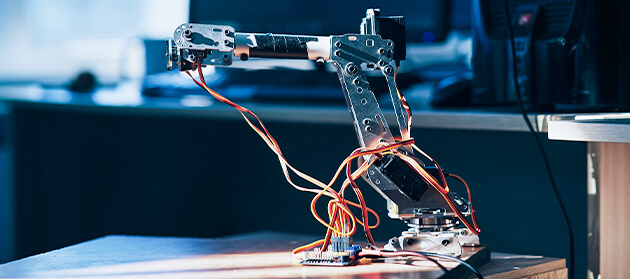 A robotic manipulator connected to a desktop computer in an office