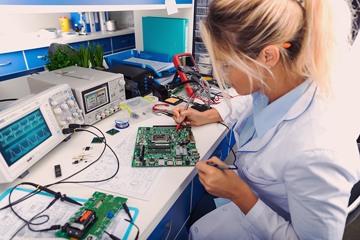 A specialist checks a circuit board in a laboratory
