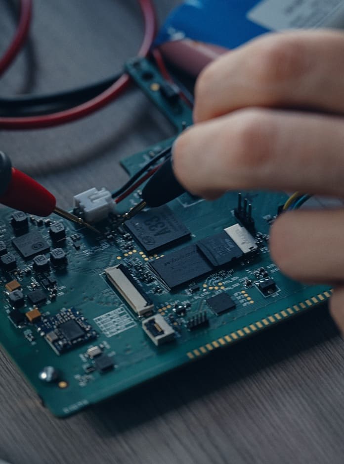An embedded developer is working on a printed circuit board.