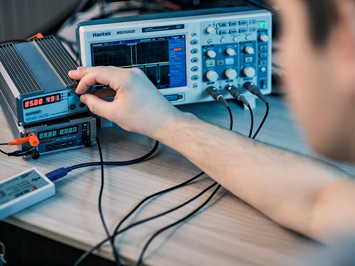 An Integra Sources engineer is adjusting the controls on electronic equipment