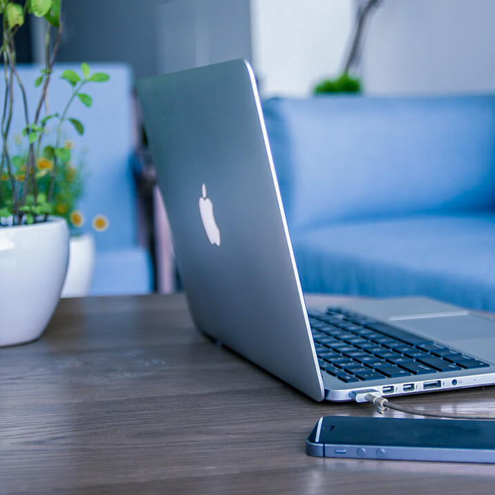 A MacBook and a smartphone on a desk.